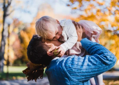 Portrét dievčatka pri hraní s otcom počas jesenného fotenia od profesionálneho fotografa