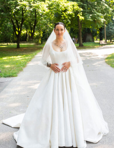 nevesta a ženích objímajúci sa pod stromami, prirodzená svadobná fotografia v jemnom svetle.