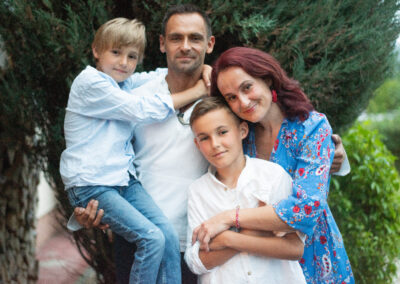 Mama a otec držia deti v náručí počas rodinného fotenia.